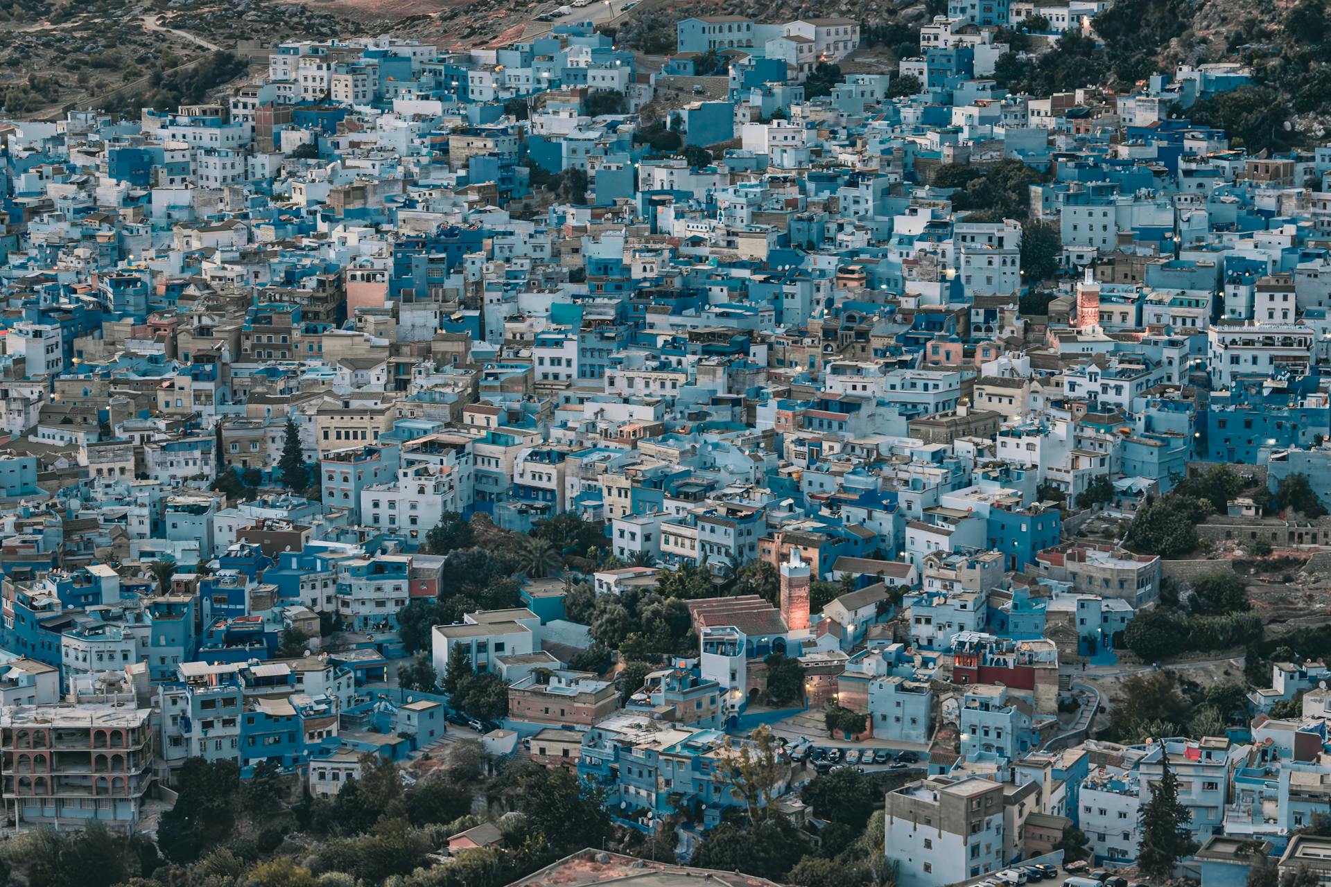 The blue streets of the Medina of Chefchaouen Morocco glowing under streetlights at night.